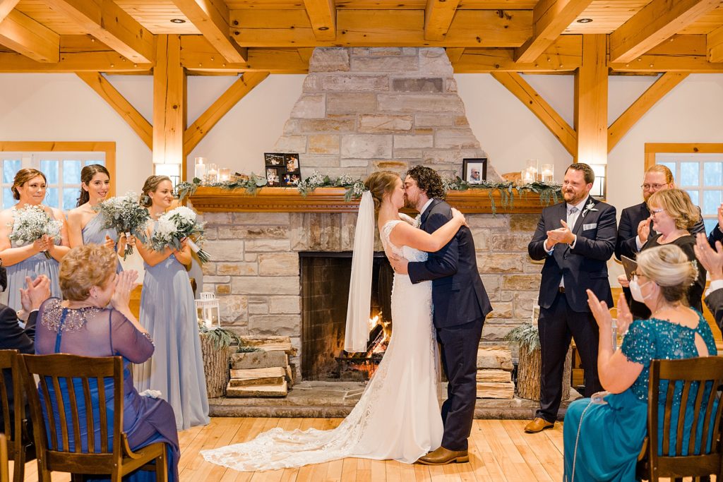 bride and grooms first kiss for temples country winter wedding photographed by Brittany Navin Photography