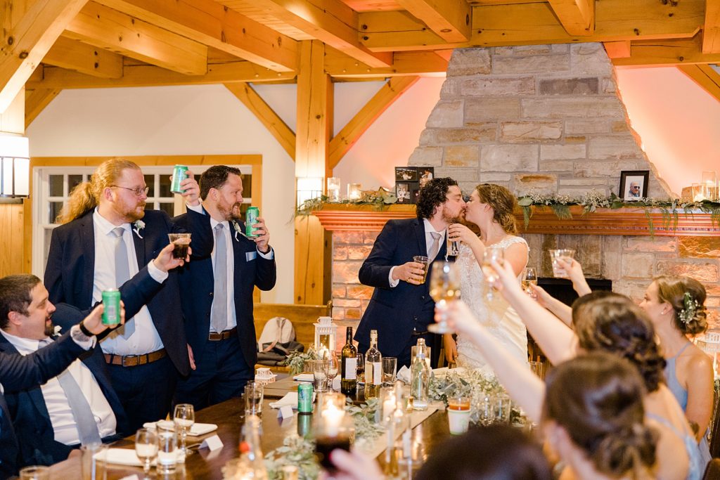 bride and groom raising a glass with wedding party during reception at temples country winter wedding photographed by Brittany Navin Photography