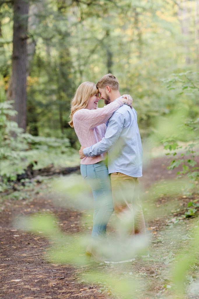Couple forehead to forehead on a trail at Arnprior engagement session at Gillies Grove photographed by Brittany Navin Photography