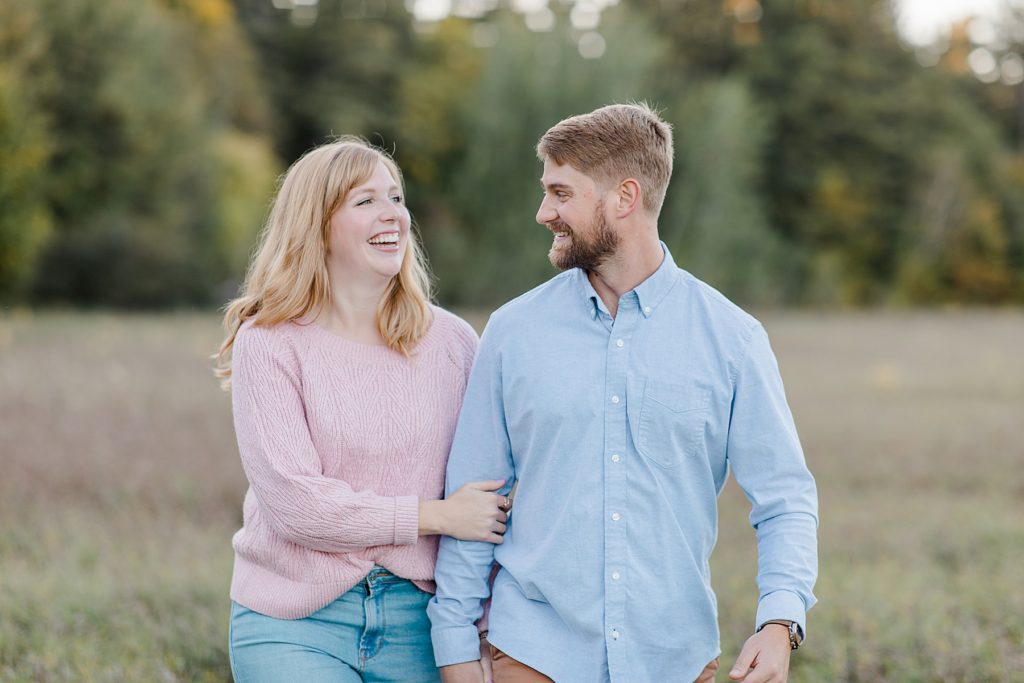 couple walking and laughing together at Arnprior engagement session at Gillies Grove photographed by Brittany Navin Photography