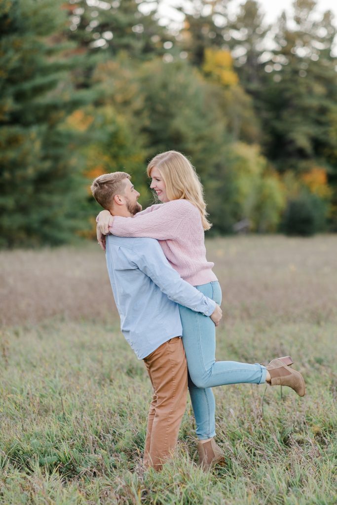 he picked his fiance up while facing her at Arnprior engagement session at Gillies Grove photographed by Brittany Navin Photography