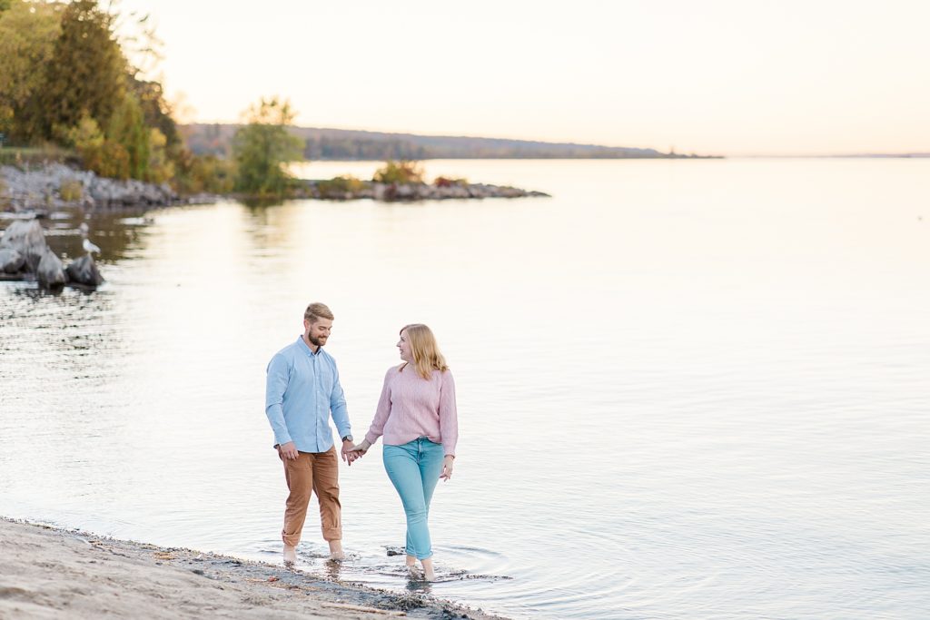 couple walking through the water at Arnprior engagement session at Robert Simpson Park photographed by Brittany Navin Photography