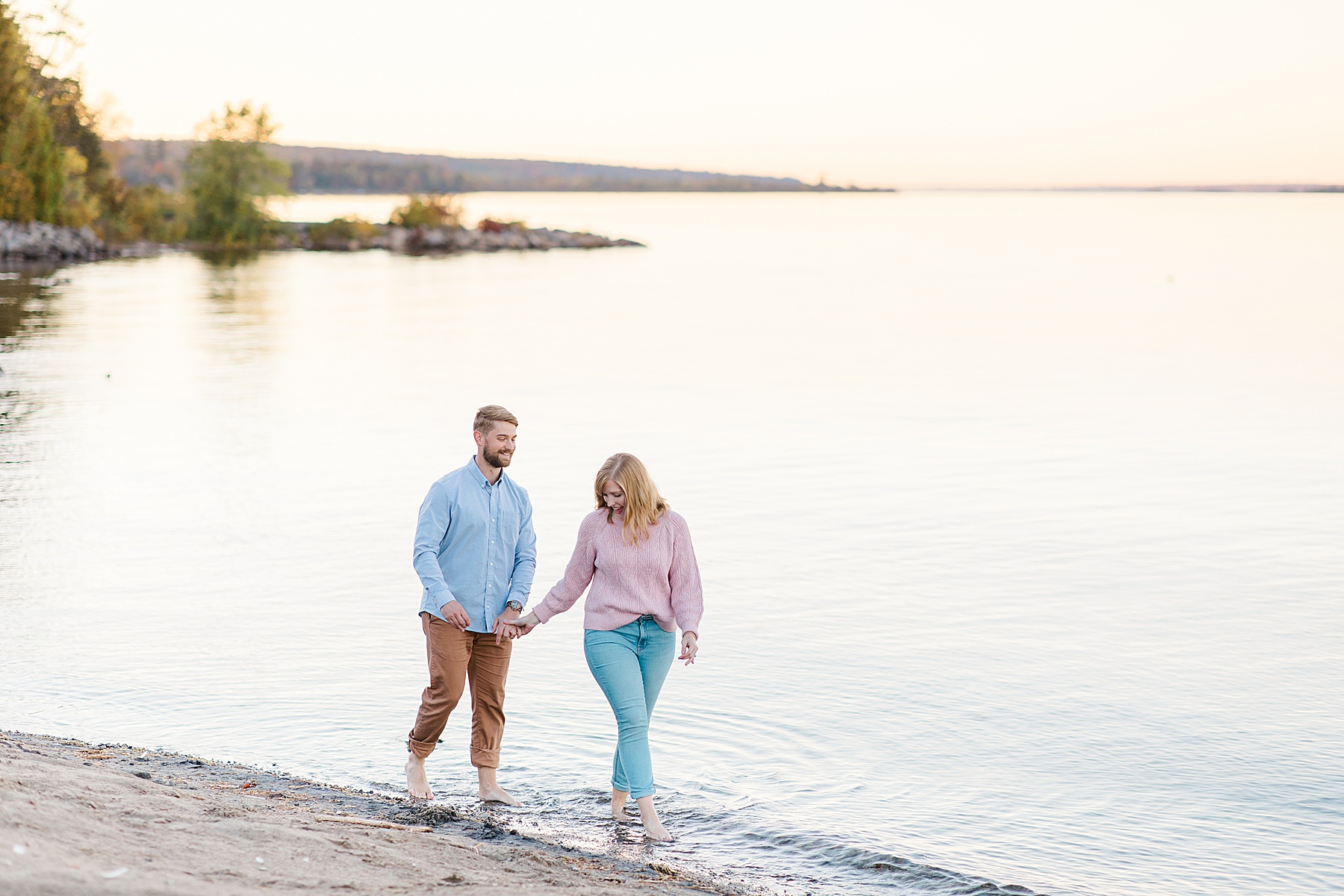 couple walking through water at Arnprior engagement session at Robert Simpson Park photographed by Brittany Navin Photography