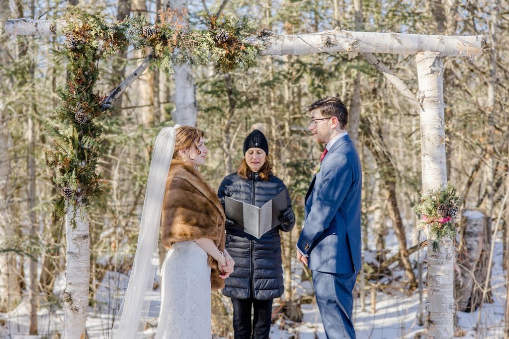 bride and groom at the altar for backyard Beckwith winter elopement photographed by Brittany Navin Photography