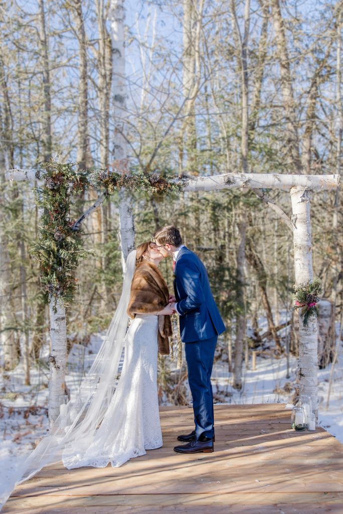bride and grooms first kiss at Beckwith winter elopement photographed by Brittany Navin Photography