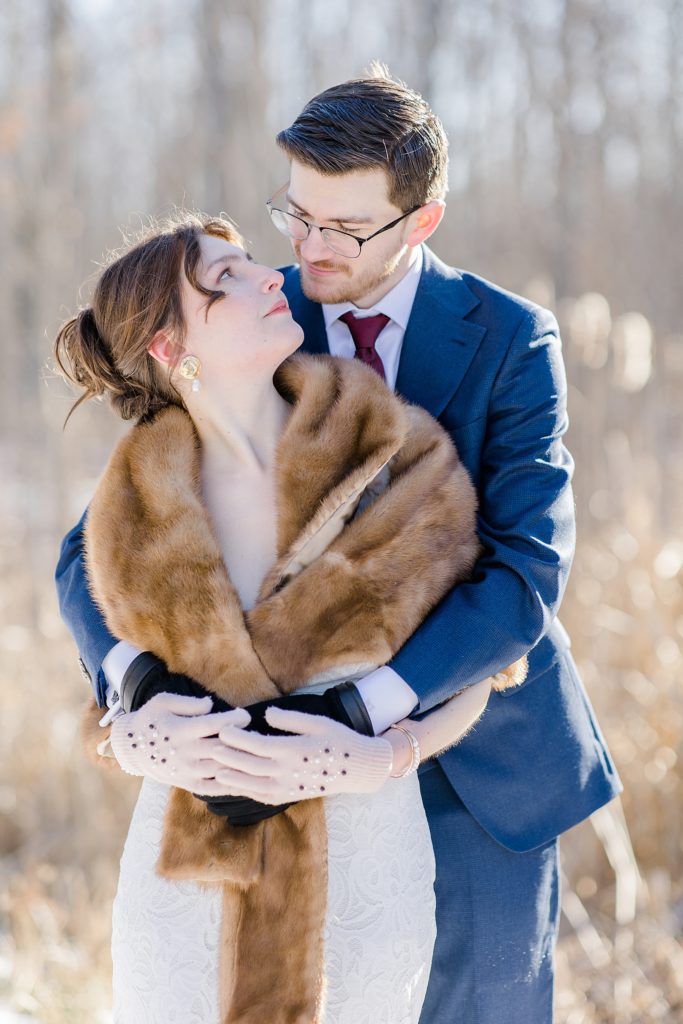 groom giving bride a hug from behind at Beckwith winter elopement photographed by Brittany Navin Photography