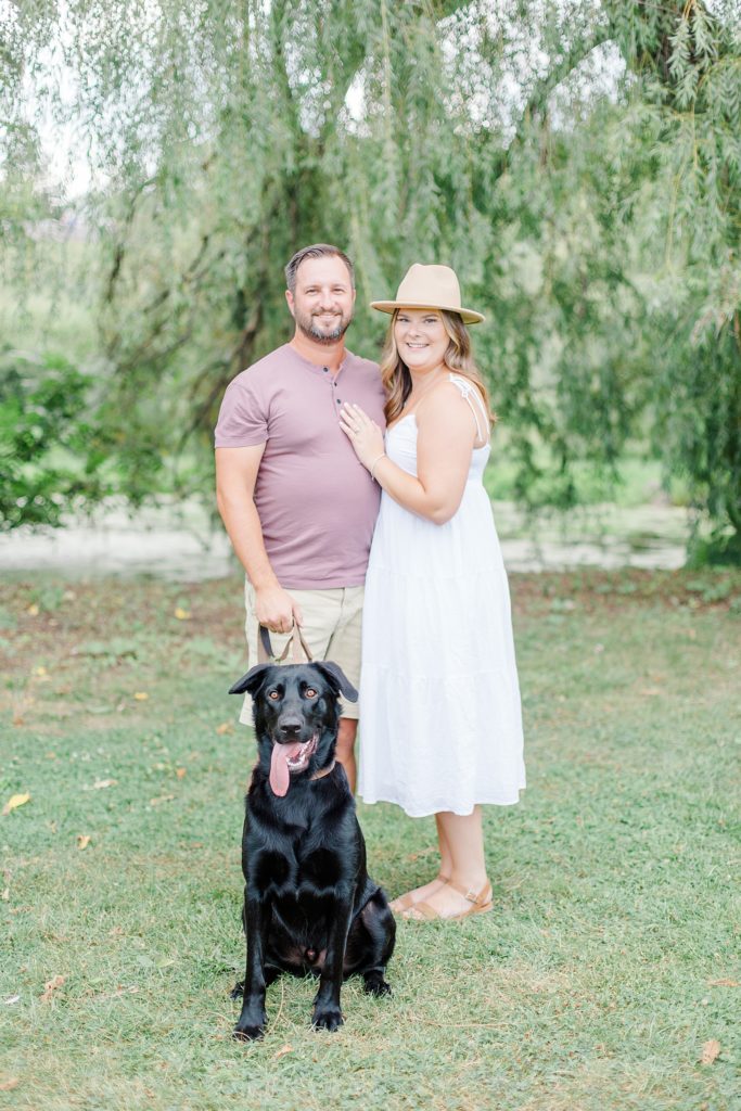 Couple looking at the camera for photo with their dog at dominion arboretum engagement session phtoographed by Brittany Navin Photography