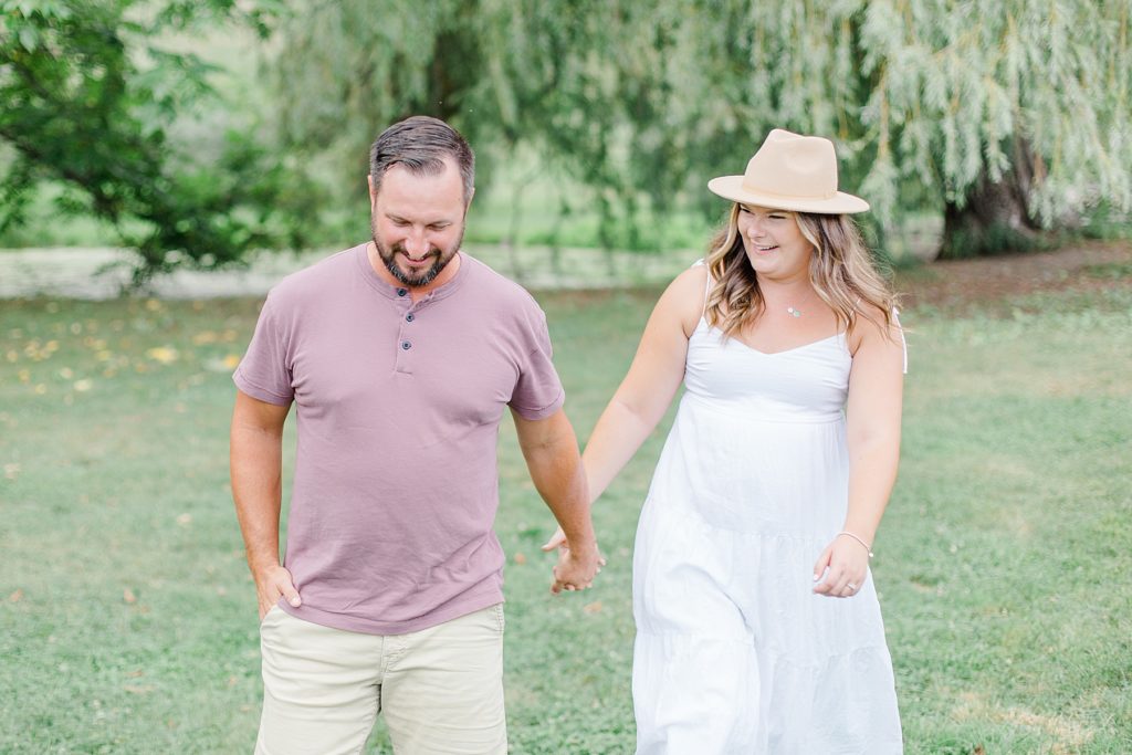 couple walking and laughing together at dominion arboretum engagement session phtoographed by Brittany Navin Photography
