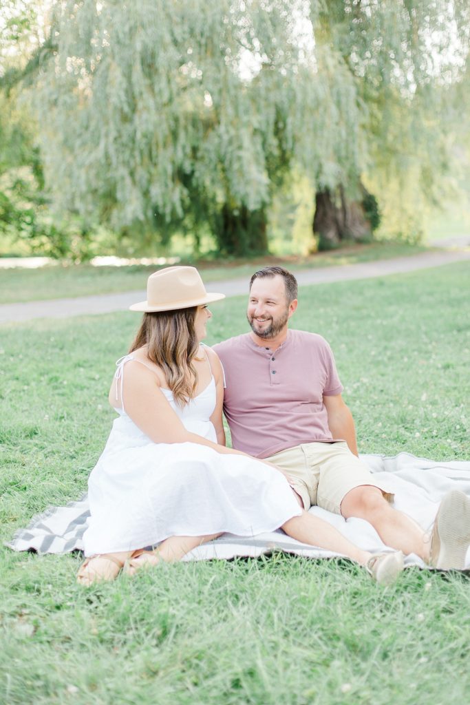 couple sitting on picnic blanket in the summer at dominion arboretum engagement session phtoographed by Brittany Navin Photography