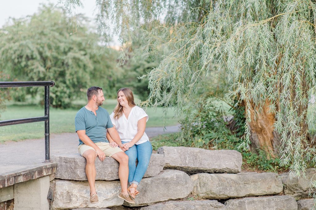 couple sitting on rocks by a little creek at dominion arboretum engagement session phtoographed by Brittany Navin Photography