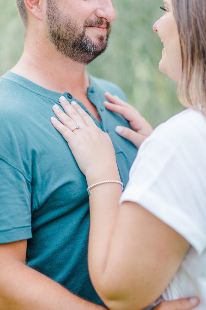 close up of engagement ring on her hand as her hand is placed on his chest at dominion arboretum engagement session phtoographed by Brittany Navin Photography