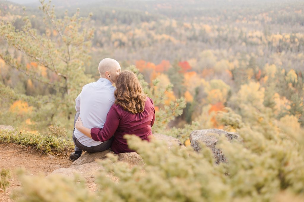 couple sitting and enjoying the view at eagle's nest fall engagement photographed by Brittany Navin Photography