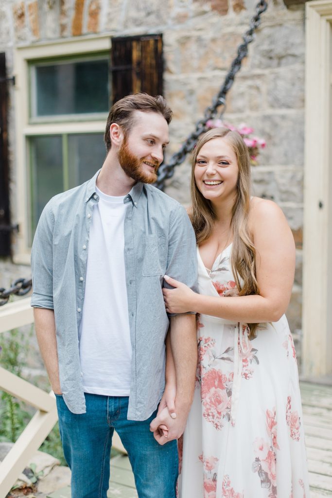 she is laughing at camera while he is looking at her at mill of kintail engagement session photographed by Brittany Navin Photography