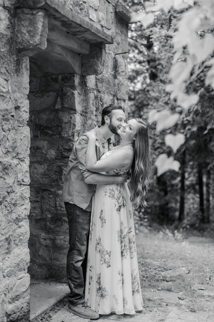 couple together by stone wall at mill of kintail engagement session photographed by Brittany Navin Photography