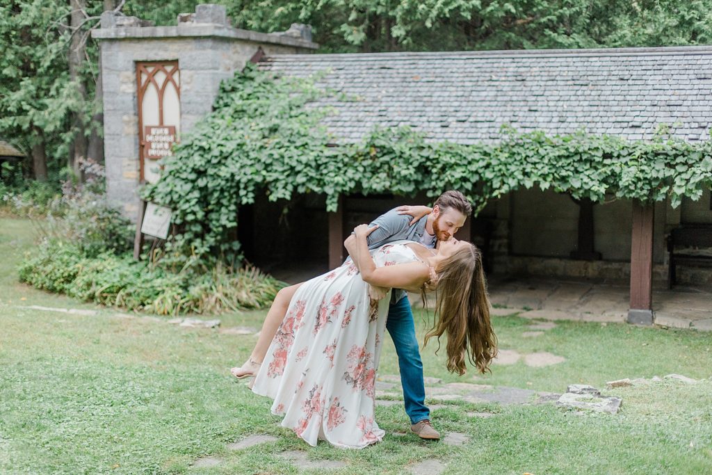 couple dipping down for a kiss at mill of kintail engagement session photographed by Brittany Navin Photography