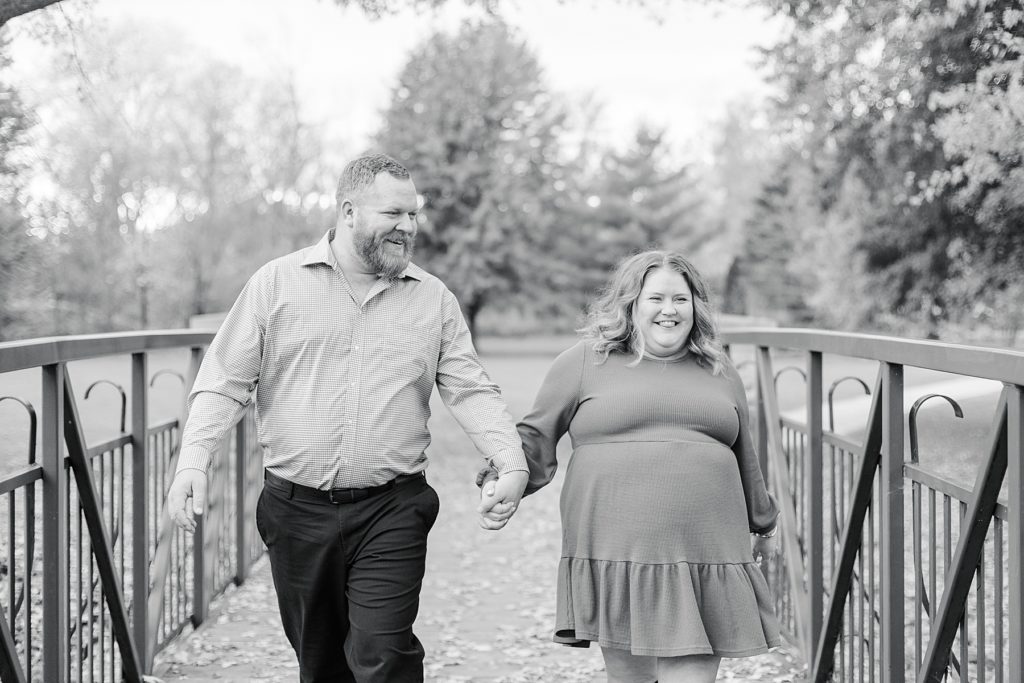couple walking across bridge At Stewart Park Engagement photographed by Brittany Navin Photography
