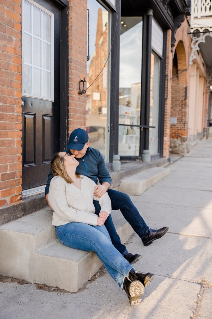 couple sitting on step at Downtown Almonte Engagement Session photographed by Brittany Navin Photography