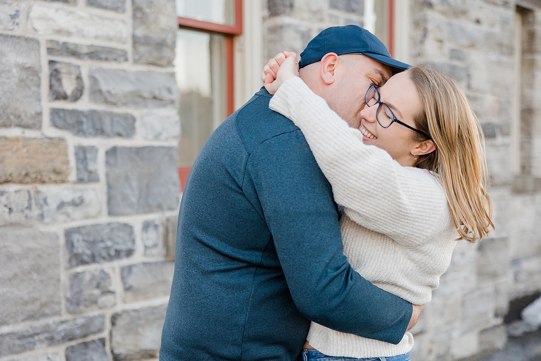 couple smiling and hugging at Downtown Almonte Engagement Session photographed by Brittany Navin Photography