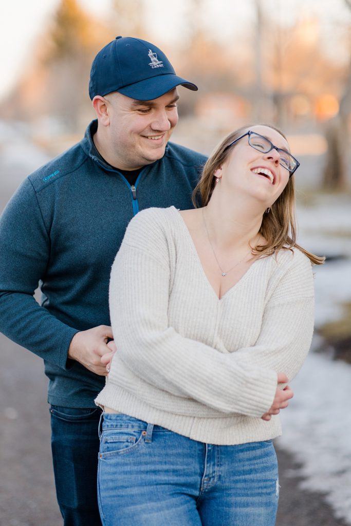 he is tickling her to make her laugh at Downtown Almonte Engagement Session photographed by Brittany Navin Photography