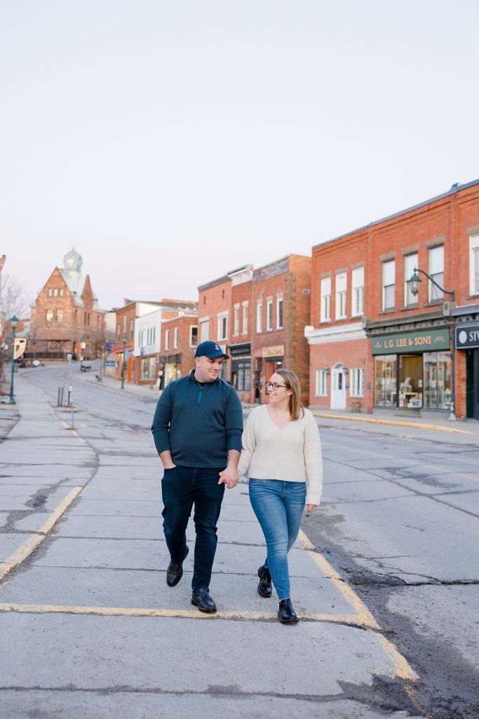 couple walking through town at Downtown Almonte Engagement Session photographed by Brittany Navin Photography