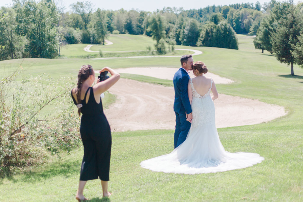 Brittany Navin Photography taking an image of bride and groom at lanark wedding at timber run golf course while ensuring clients are comfortable in front of camera