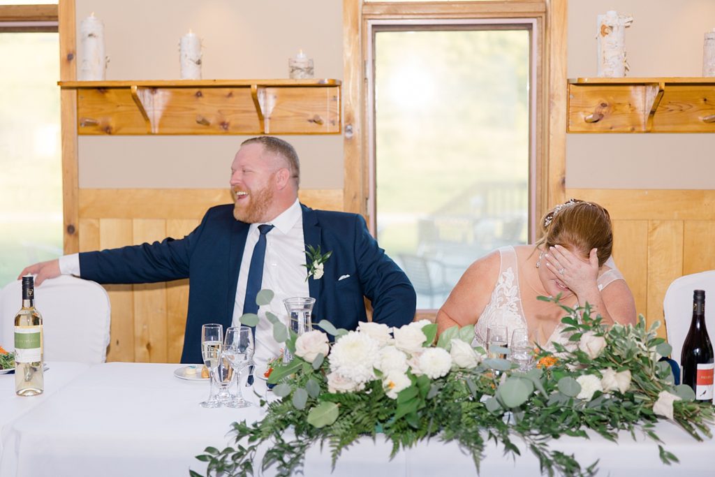 bride and groom laughing during reception at calabogie peaks summer wedding photographed by Brittany Navin Photography