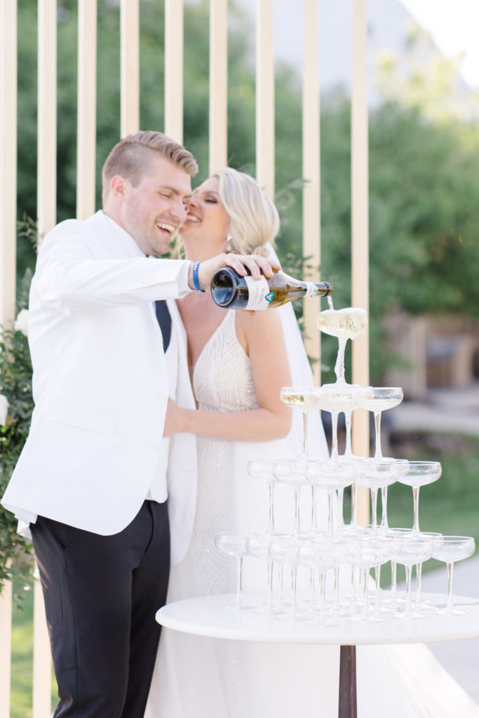 Bride and groom pouring a champagne tower as one of the events at Stonefields wedding to ensure wedding guests have an amazing experience photographed by Brittany Navin Photography while working for Stephanie Mason and Co. 