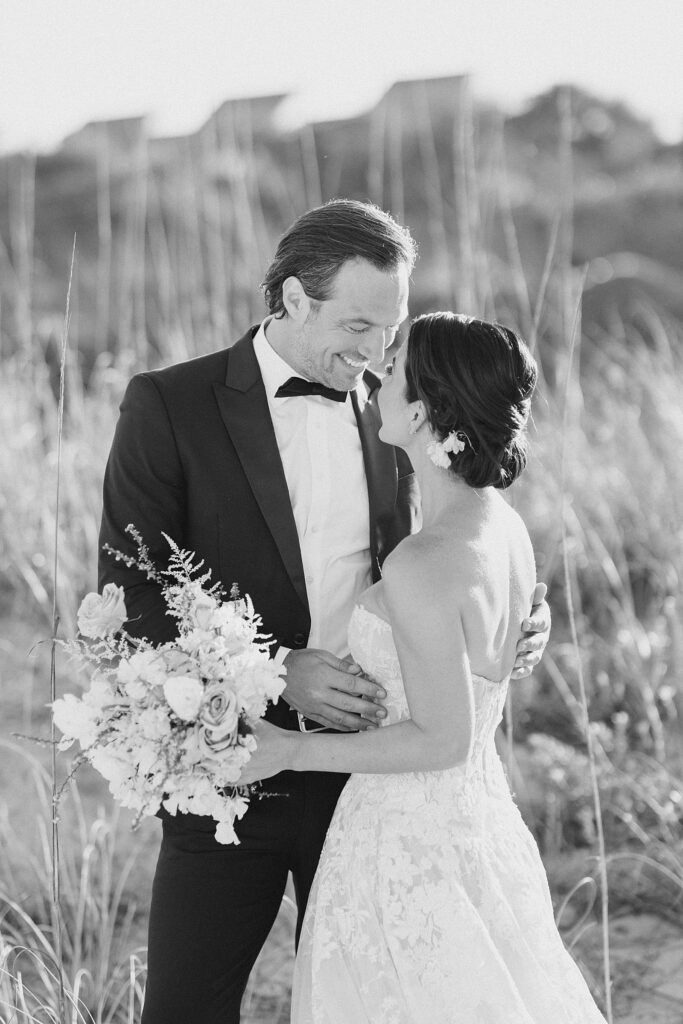 black and white image of husband and wife during portraits at the coastal opulence beach wedding editorial photographed by Brittany Navin Photography