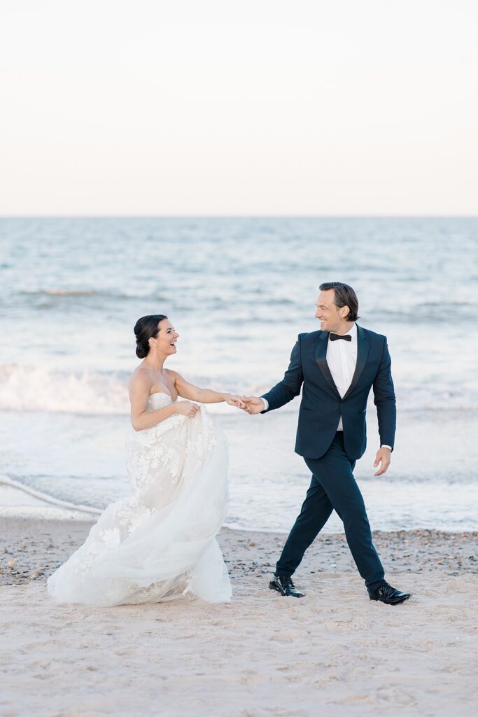 bride and groom happily walking along the beach after officially getting married at destination wedding photographed by Brittany Navin Photography 
