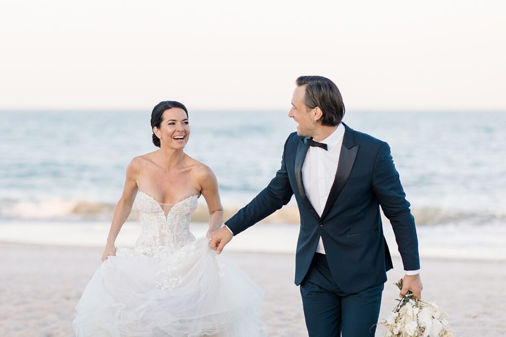 husband and wife are extremely happy as they realize they are officially married during wedding portraits at the coastal opulence beach wedding editorial photographed by Brittany Navin Photography