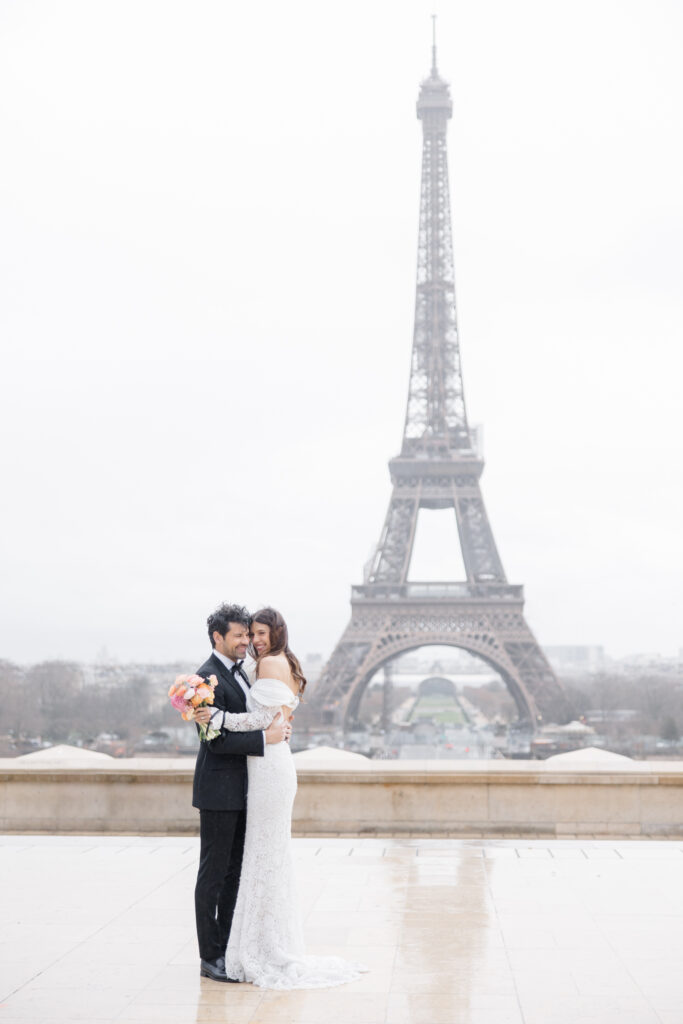 bride and groom embracing during portraits in front of Eiffel Tower during elopement editorial in Paris, France, photographed by Brittany Navin Photography, an Ottawa based destination wedding photographer.
