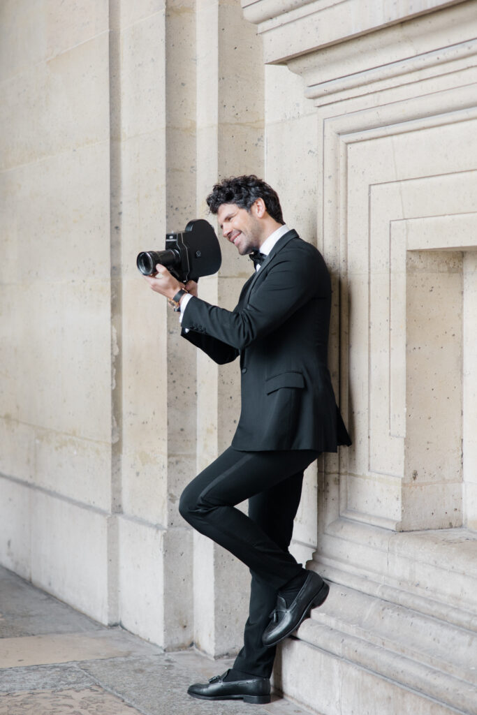 Groom is videoing his bride from his point of view on an old film camera during elopement editorial in Paris, France, photographed by Brittany Navin Photography, an Ottawa based destination wedding photographer.