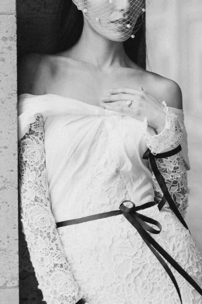 detail image of bride showing off ring and bird cage veil photographed at the Louvre during a Paris elopement photographed by Brittany Navin Photography