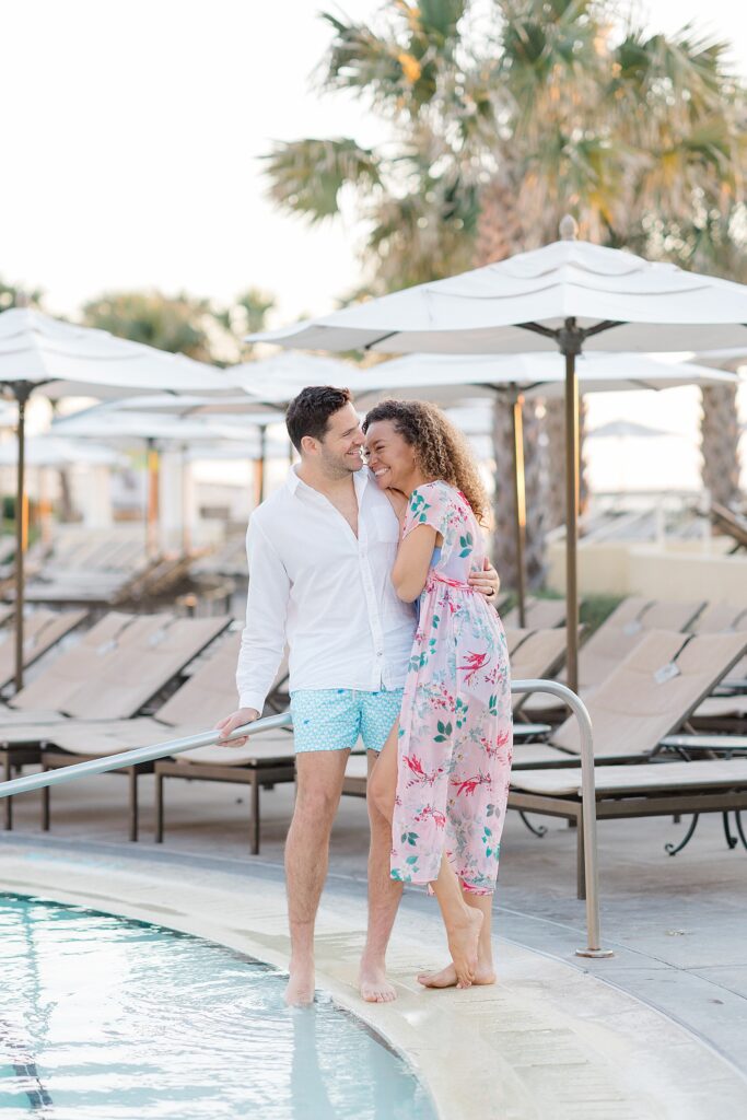 couple laughing together by the pool at Amelia Island Honeymoon Session photographed by Brittany Navin Photography 