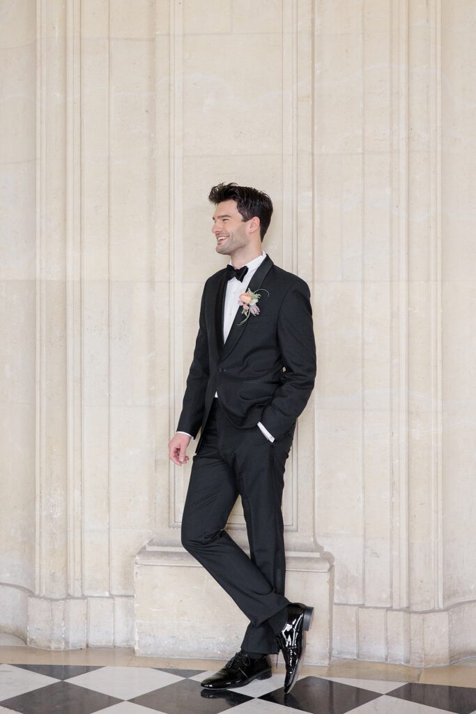 Groom portrait using the stunning architecture as a backdrop at Chateau De Champlatreux Wedding in Paris, France photographed by destination wedding photographer Brittany Navin Photography