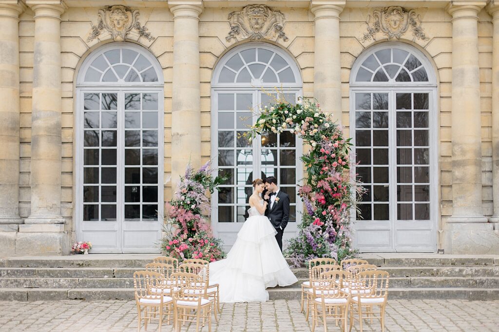 bride and groom portrait at wedding aktar of luscious blooms at Chateau De Champlatreux Wedding in Paris, France photographed by destination wedding photographer Brittany Navin Photography