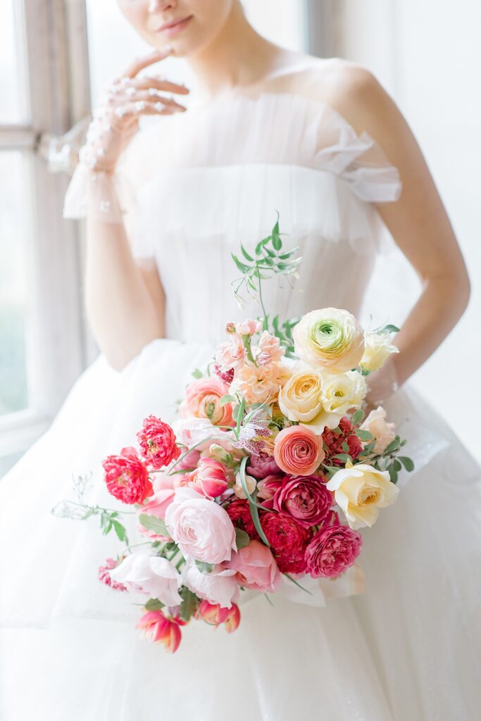 luscious bridal bouquet with pops of pink at Chateau De Champlatreux Wedding in Paris, France photographed by destination wedding photographer Brittany Navin Photography
