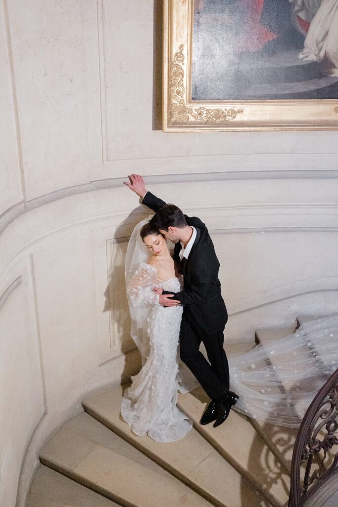 direct flash styled bride and groom portrait on the stairs indoors at Chateau De Champlatreux Wedding in Paris, France photographed by destination wedding photographer Brittany Navin Photography
