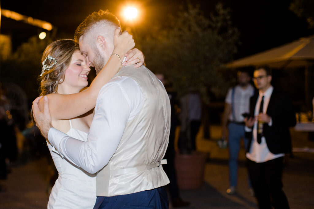 bride and groom share a last wedding dance in outdoor courtyard at Rome countryside wedding held at Tenuta La Porta Sul Lago photographed by Destination Wedding Photographer Brittany Navin Photography