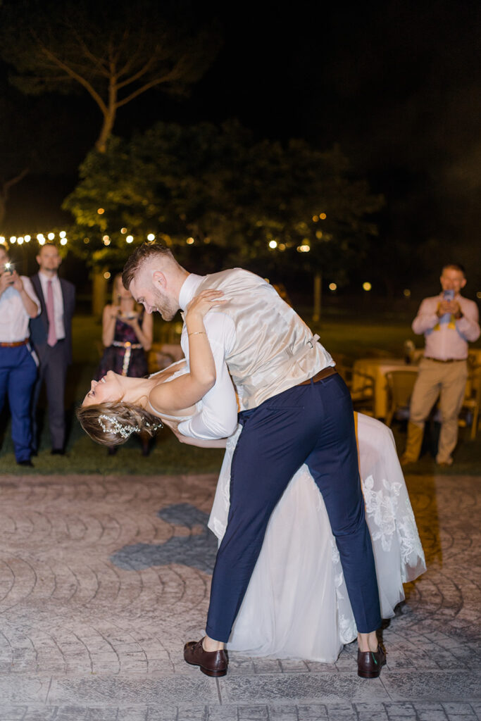 bride and grooms first dance in outdoor courtyard surrounded by twinkle lights at Rome countryside wedding held at Tenuta La Porta Sul Lago photographed by Destination Wedding Photographer Brittany Navin Photography