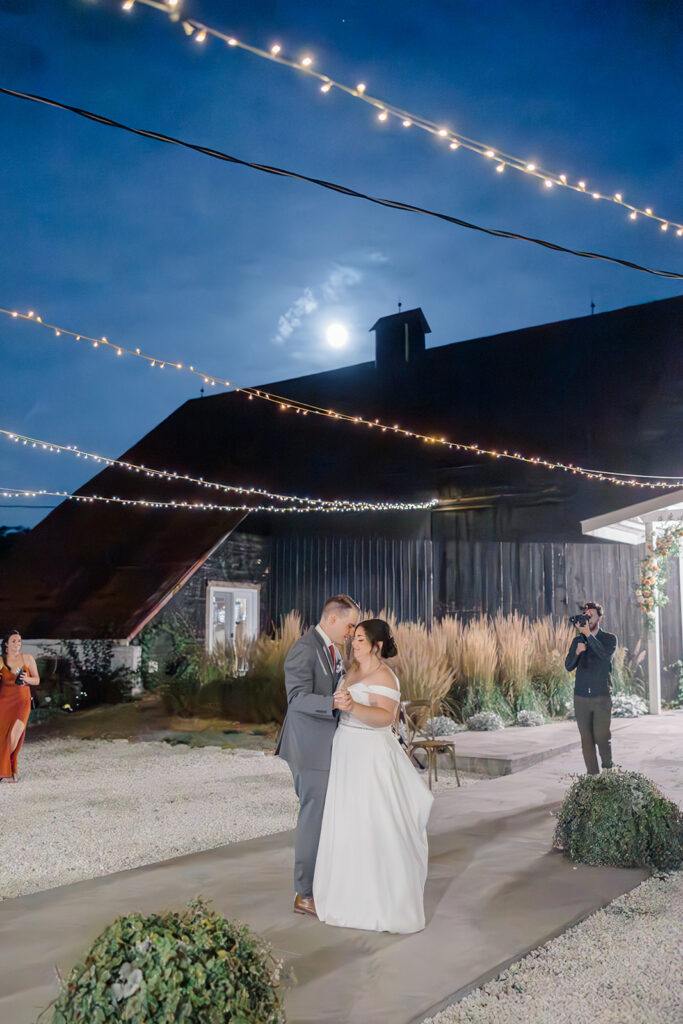 First dance as the sun goes down and the moon comes out underneath teh twinkle lights at Bleeks and Bergamot wedding in Ashton, Ontario photographed by Ottawa wedding photographer, Brittany Navin Photography