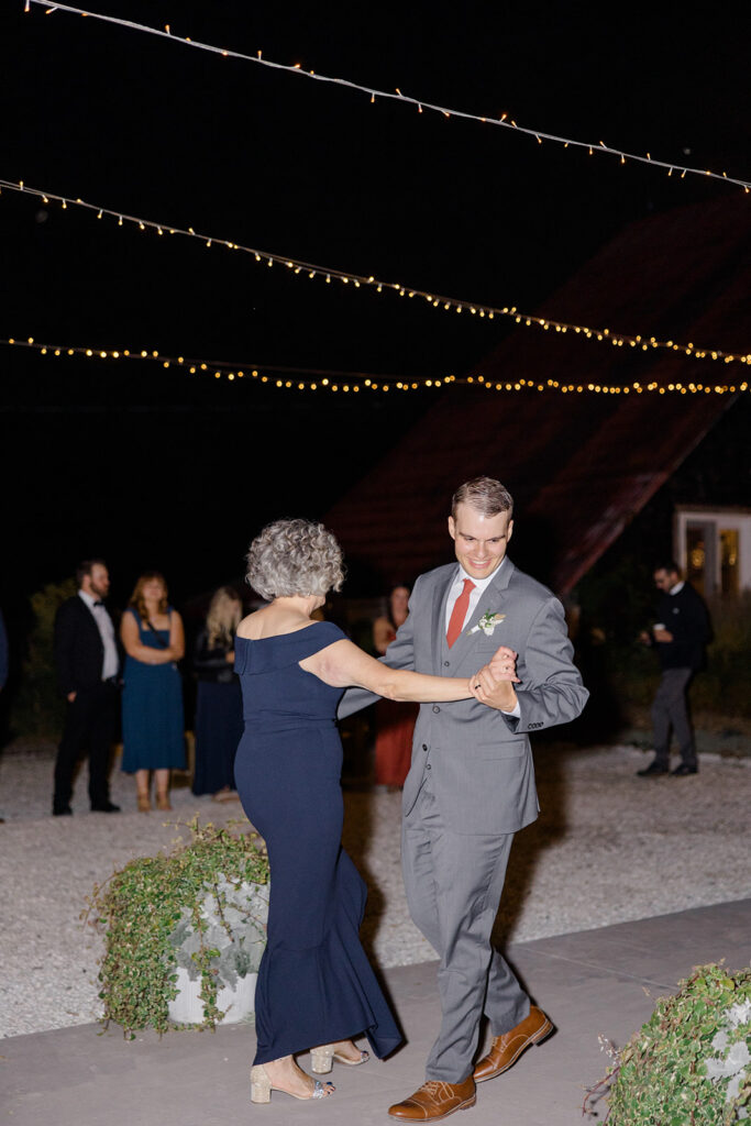 Mother-son wedding dance under the twinkle lights at Bleeks and Bergamot wedding in Ashton, Ontario photographed by Ottawa wedding photographer, Brittany Navin Photography