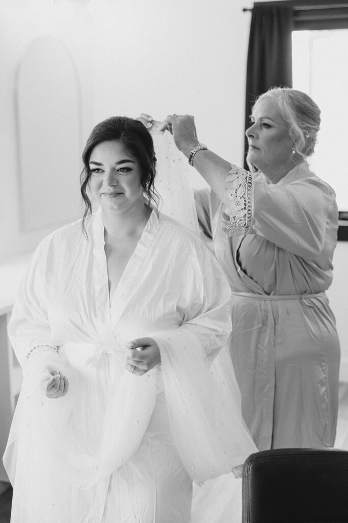 Mother of the bride helping bride put her cathedral veil in the bridal suite at Bleeks and Bergamot wedding in Ashton, Ontario photographed by Ottawa wedding photographer, Brittany Navin Photography