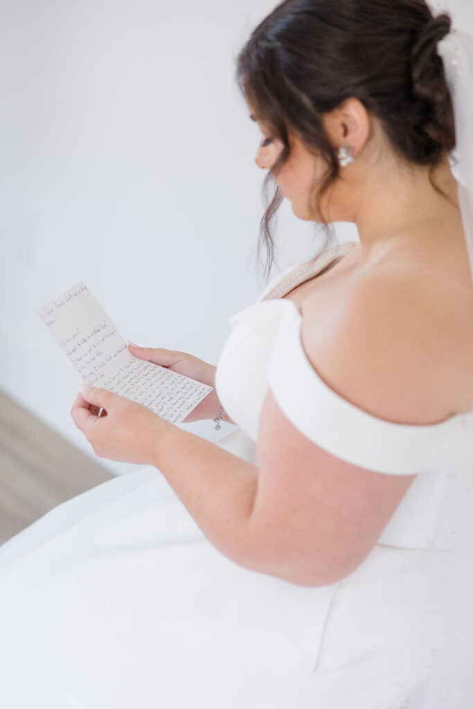 bride reading a sentimental note from her soon to be husband before heading to see him for their first look at Bleeks and Bergamot wedding in Ashton, Ontario photographed by Ottawa wedding photographer, Brittany Navin Photography