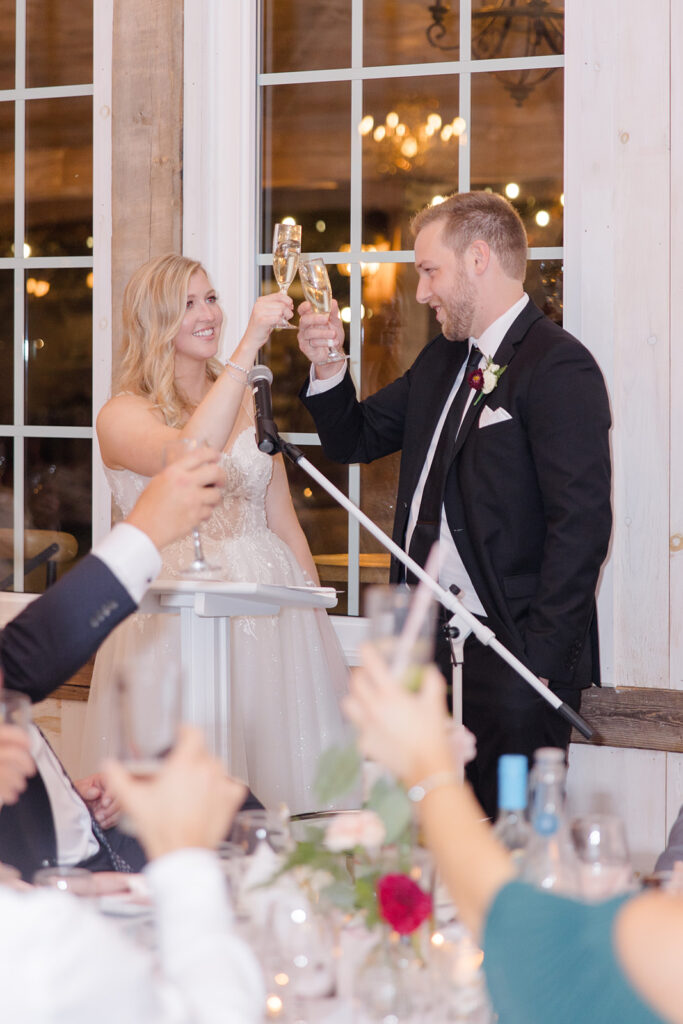 bride and groom cheers during their thank you toast photographed by Brittany Navin Photography