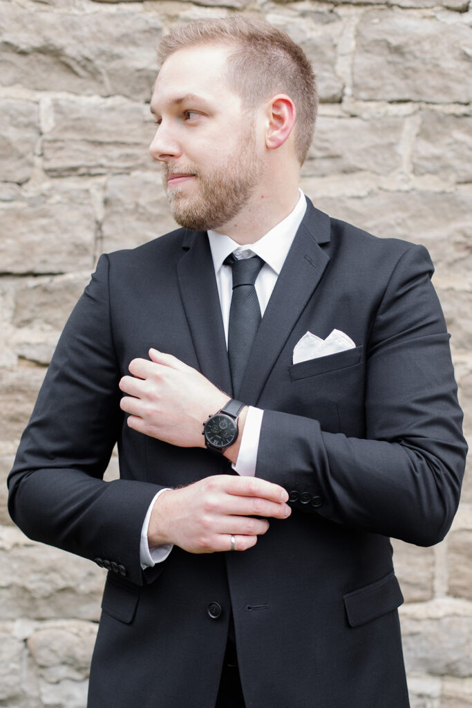 groom adjusting his sleeves as he gets ready at Stonefields Estate wedding photographed by Ottawa Wedding Photographer Brittany Navin Photography
