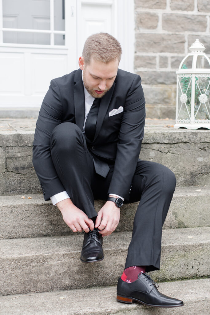 groom putting on his shoes at Stonefields Estate wedding photographed by Ottawa Wedding Photographer Brittany Navin Photography