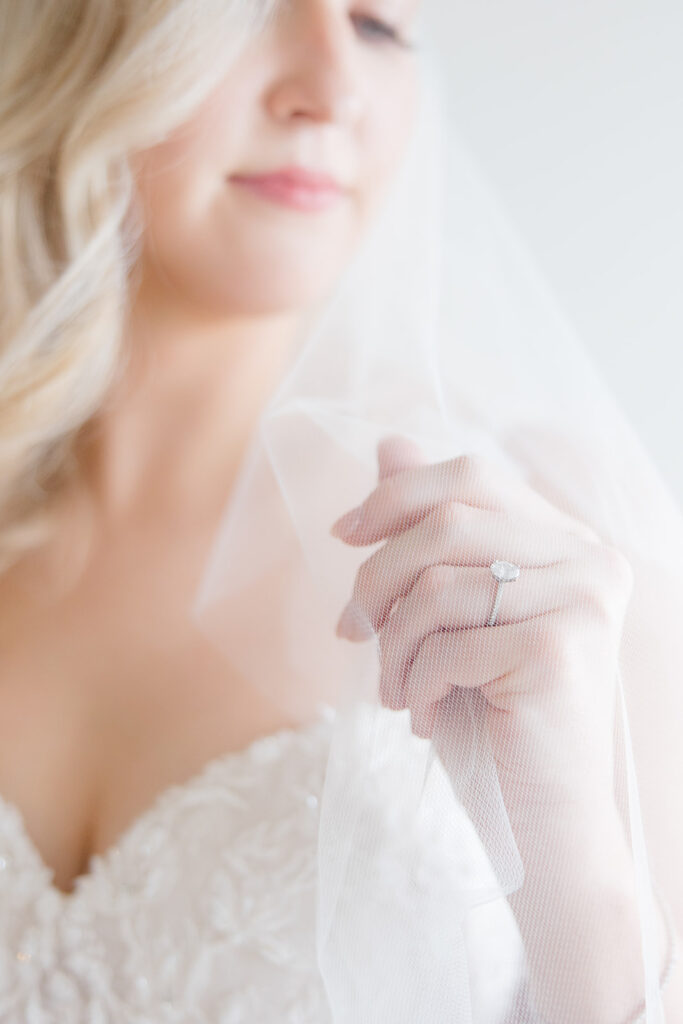 detail of brides engagement ring as she adjusts her wedding veil at Stonefields Estate wedding photographed by Ottawa Wedding Photographer Brittany Navin Photography