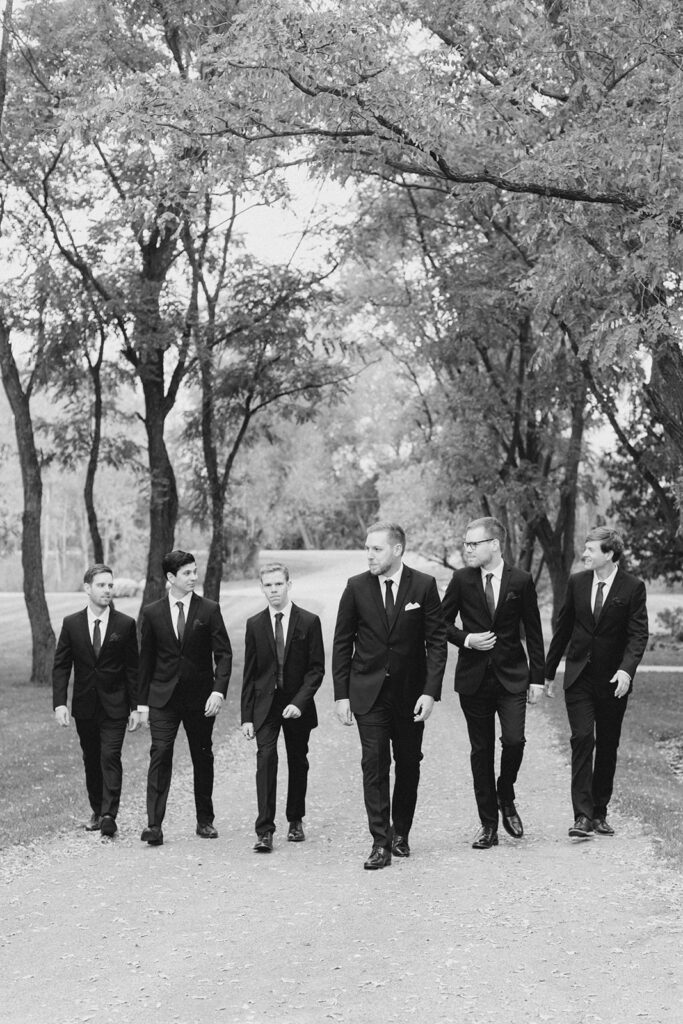groom and groomsmen walking together as they prepare for the ceremony at Stonefields Estate wedding photographed by Ottawa Wedding Photographer Brittany Navin Photography