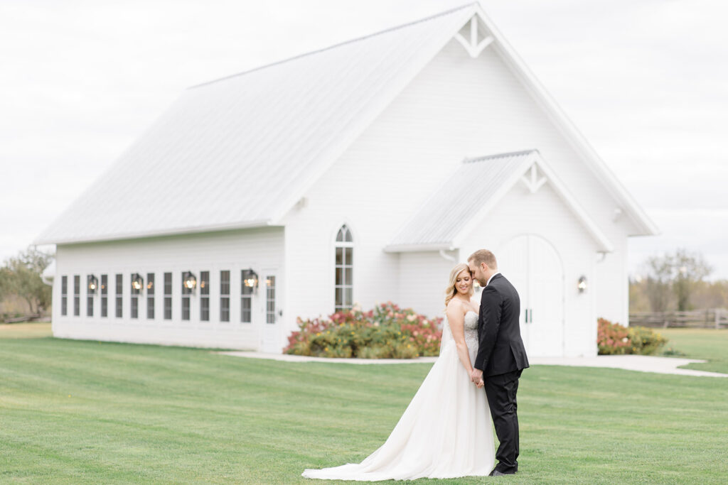 bride and groom with ceremony house in the background at Stonefields Estate wedding photographed by Ottawa Wedding Photographer Brittany Navin Photography